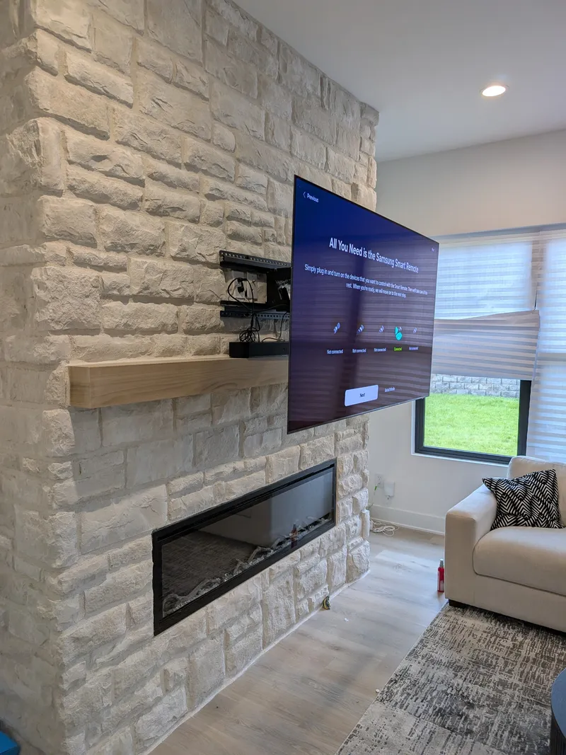 MantelMount pull-down TV mount extended from stone fireplace showing mechanism