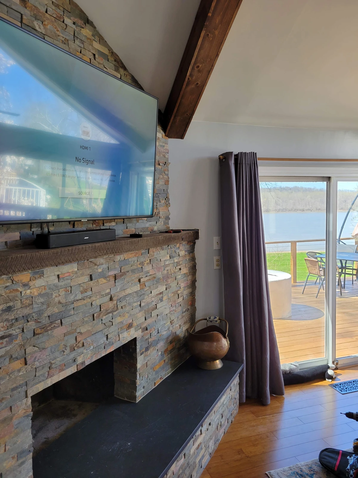 TV and soundbar mounted on multicolor stacked stone fireplace in Louisville KY home