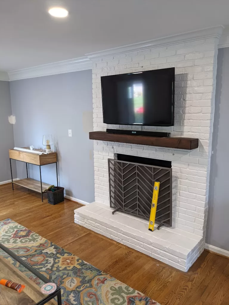 TV mounted on a white brick fireplace, blending modern entertainment with classic design. | TV Mounting Louisville Kentucky