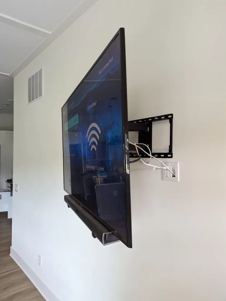 TV on drywall with full-motion mount, outlet behind, and soundbar mounted below in Louisville, KY